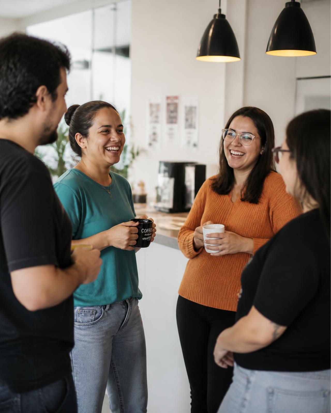 Colegas de trabalho conversando e sorrindo durante uma pausa no escritório